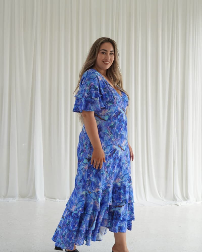 Side of a model wearing a size 4 Marcy ruffle maxi dress in Abalone Shell by Dani Marie. | dia_product_style_image_id:353077